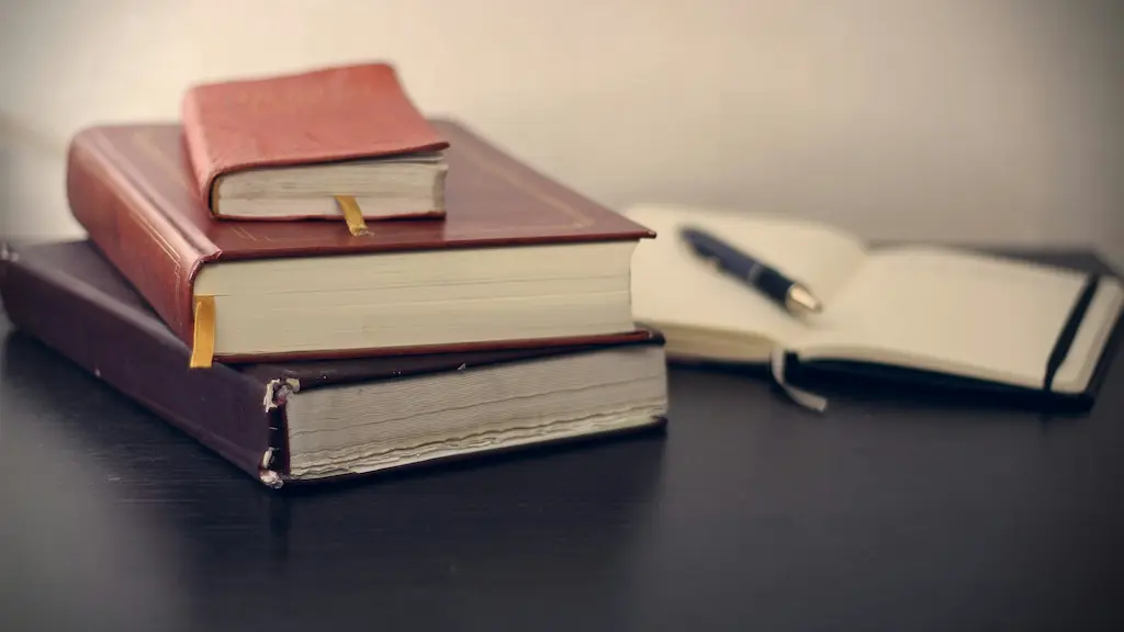 Drei übereinanderliegende Gesetzbücher auf einem Schreibtisch, im Hintergrund ein geöffnetes Heft mit Kugelschreiber – symbolisiert die schriftliche Abgabe einer Unterlassungserklärung